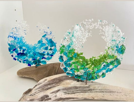 Two mini fused glass waves in blue, green and clear glass standing on driftwood bases